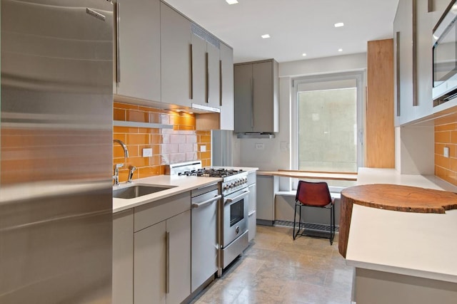 kitchen with stainless steel appliances, sink, decorative backsplash, and gray cabinets