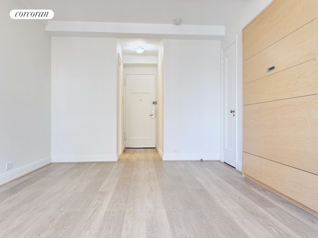 empty room featuring visible vents, light wood-style flooring, and baseboards