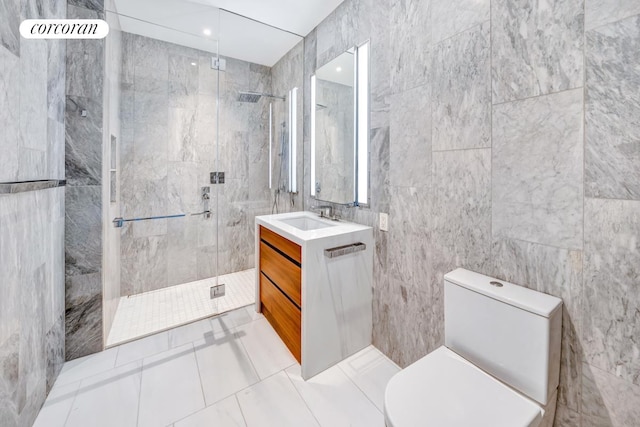 full bathroom with vanity, a tile shower, toilet, and tile walls