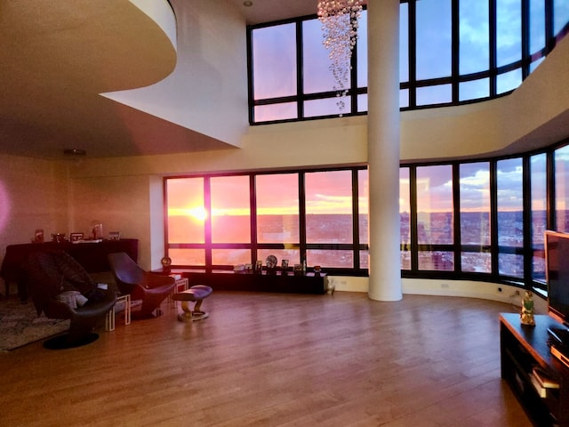 living room with a towering ceiling and wood finished floors