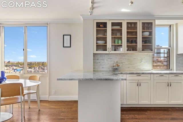 bar featuring backsplash, light stone countertops, and white cabinetry