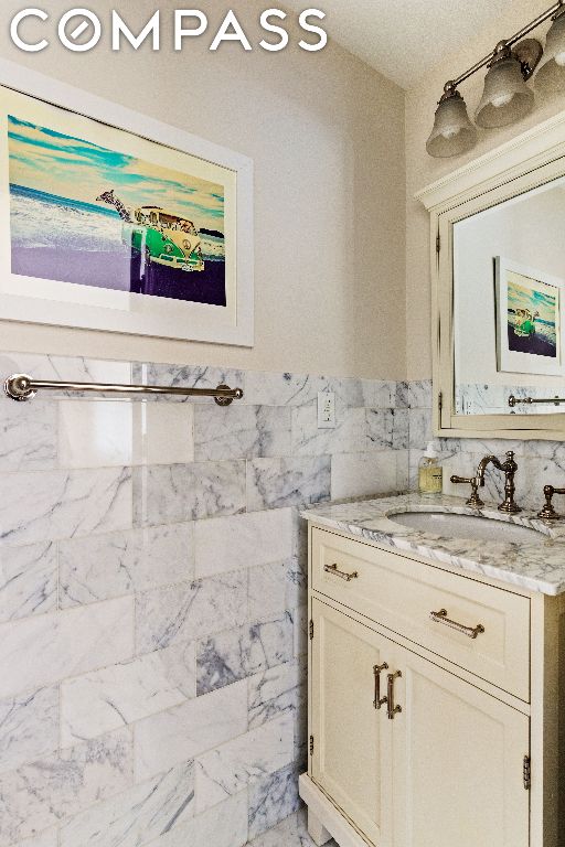 bathroom featuring tile walls and vanity