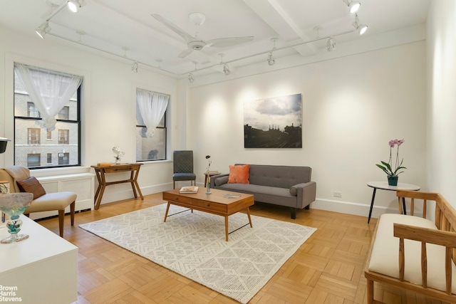 living area featuring ceiling fan, baseboards, rail lighting, and radiator