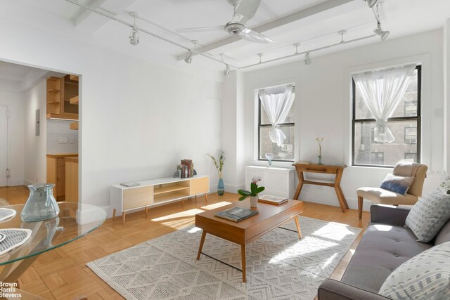 living room featuring track lighting, radiator, ceiling fan, and baseboards