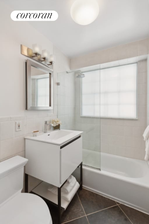 full bathroom with plenty of natural light, tiled shower / bath combo, vanity, and tile patterned flooring