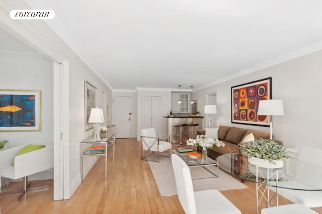 living room with light hardwood / wood-style flooring and crown molding