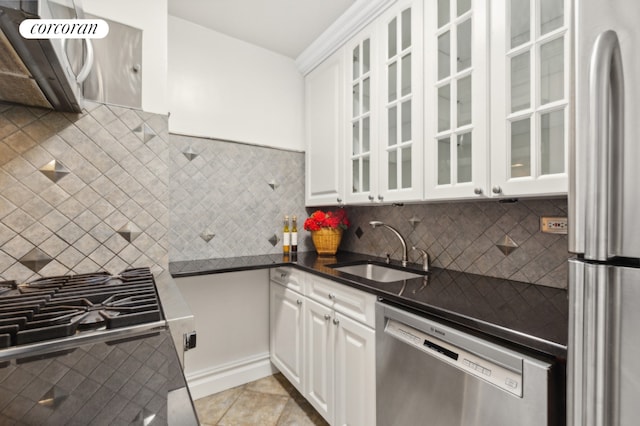 kitchen featuring light tile patterned floors, stainless steel appliances, backsplash, white cabinets, and sink