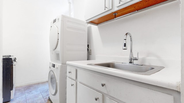 washroom featuring cabinets, stacked washer / dryer, sink, and light tile patterned floors