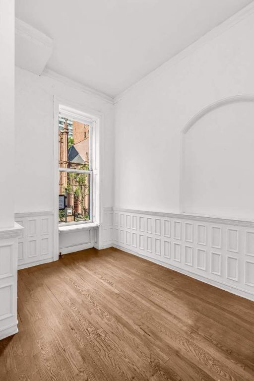 empty room featuring ornamental molding and hardwood / wood-style floors