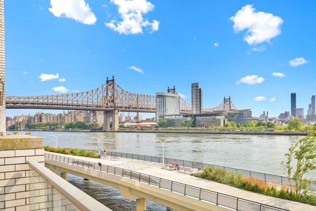 water view with a notable bridge, nearby urban area, and fence