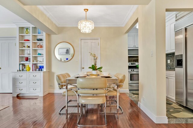 dining space featuring dark wood finished floors, a chandelier, ornamental molding, and baseboards