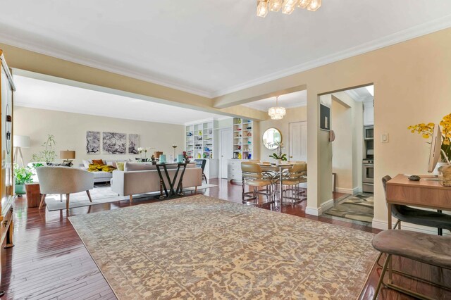living area featuring a chandelier, crown molding, hardwood / wood-style floors, and baseboards