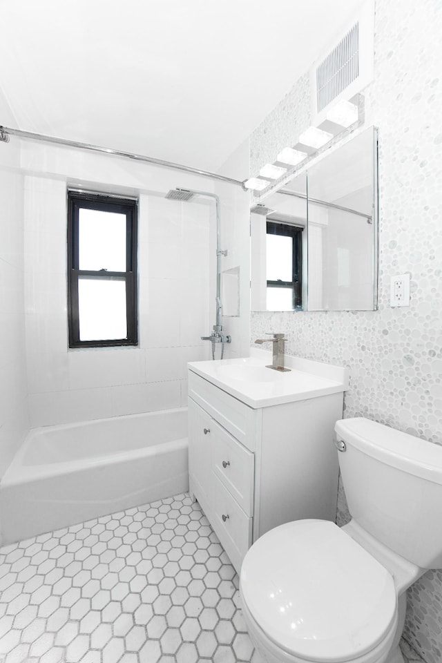 bathroom featuring toilet, shower / bathtub combination, vanity, and visible vents