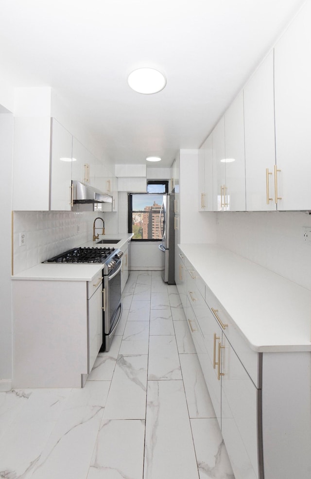 kitchen with white cabinets, a sink, under cabinet range hood, gas stove, and marble finish floor