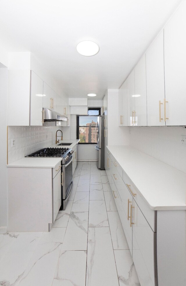 210 E Broadway Unit H1904, New York City, NY 10002 - kitchen with stainless steel appliances, under cabinet range hood, light marble finish floors, white cabinetry, and backsplash