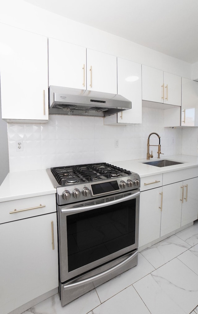 210 E Broadway Unit H1904, New York City, NY 10002 - kitchen with stainless steel gas range, under cabinet range hood, a sink, light marble finish flooring, and white cabinetry