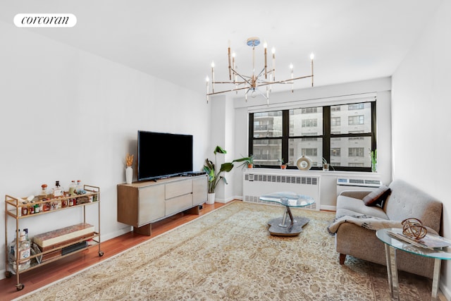 living room with hardwood / wood-style flooring, radiator, and a notable chandelier