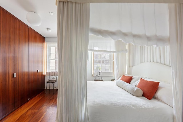 bedroom with dark hardwood / wood-style flooring and multiple windows