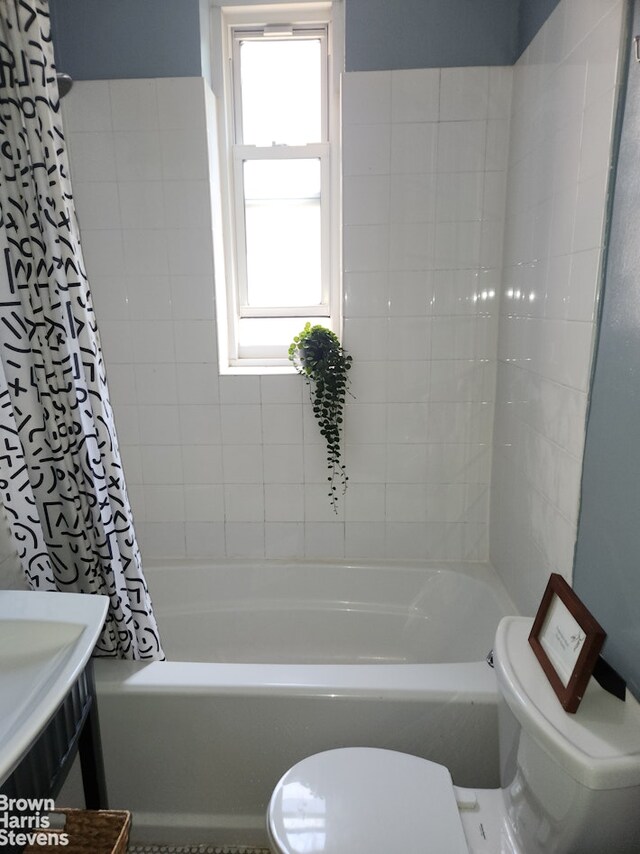 bathroom with shower / bathtub combination with curtain and toilet