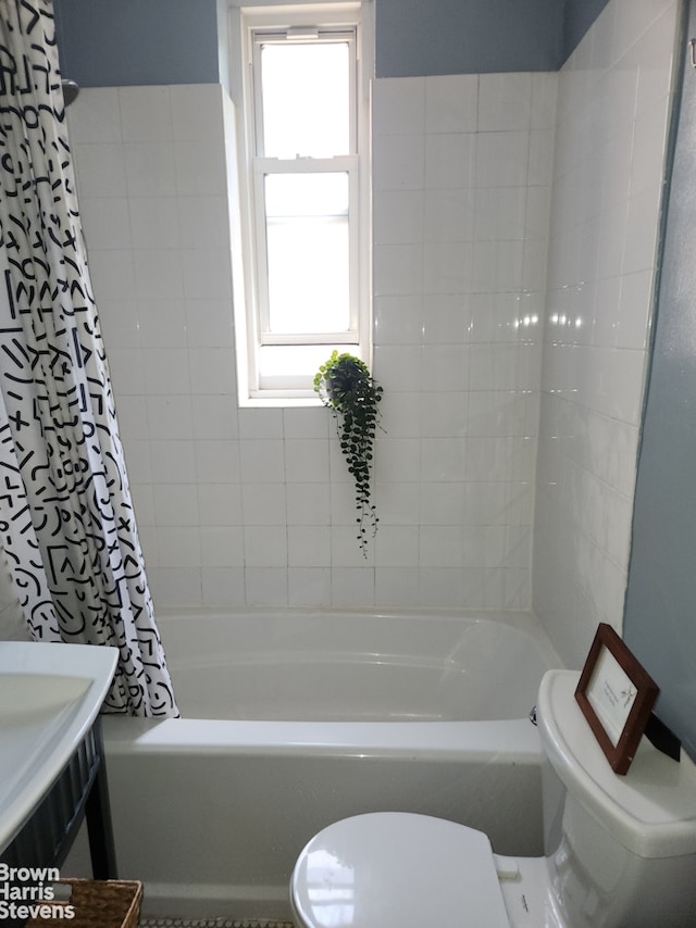 bathroom featuring toilet, shower / bath combo with shower curtain, and vanity