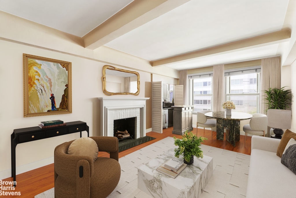 living area with light wood-style floors, a fireplace, and beam ceiling