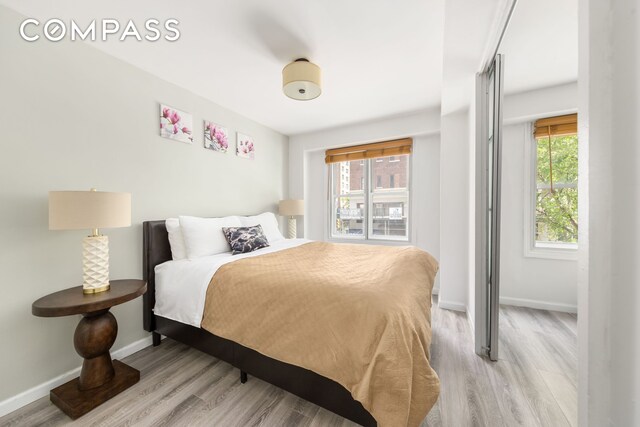 bedroom featuring light wood-type flooring and baseboards