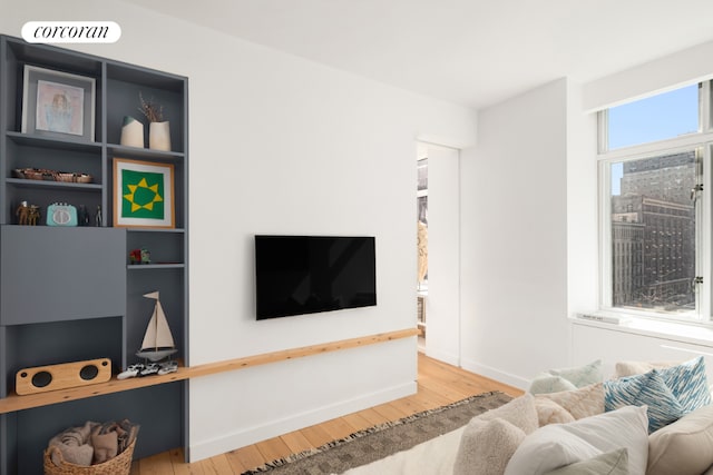 living room featuring visible vents, baseboards, and wood finished floors