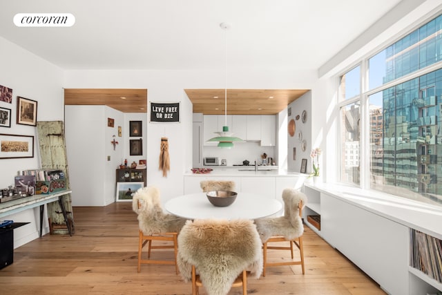 dining space with light wood-style flooring and visible vents