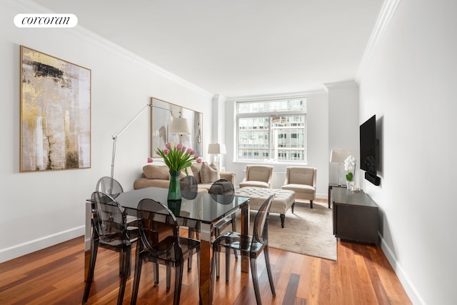 dining space with baseboards, visible vents, ornamental molding, and light wood-style flooring
