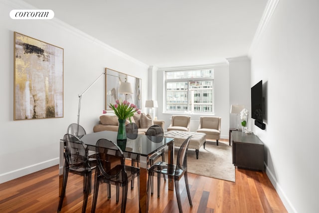 dining space featuring wood-type flooring and ornamental molding