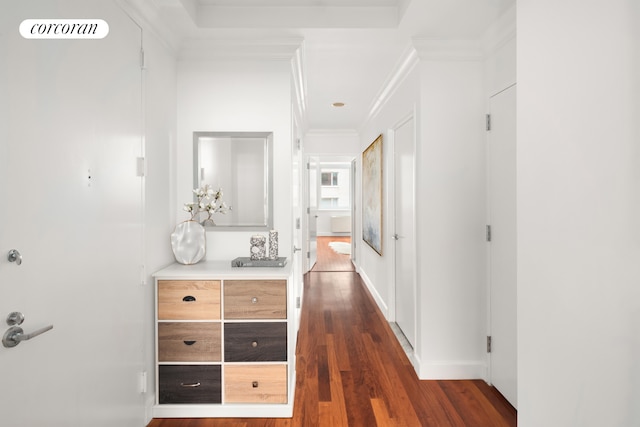 corridor with dark wood-style floors, ornamental molding, visible vents, and baseboards