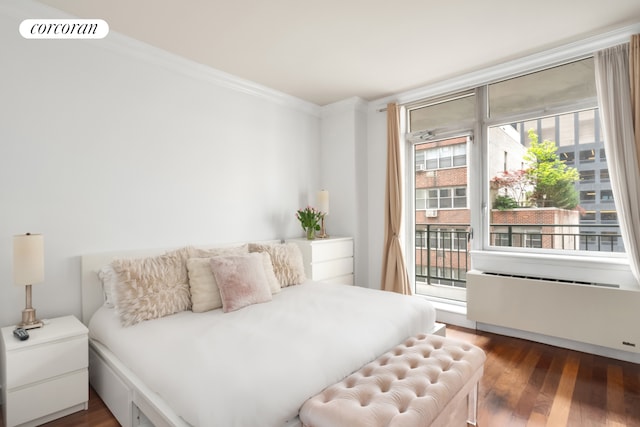 bedroom with crown molding, visible vents, wood finished floors, access to exterior, and radiator heating unit
