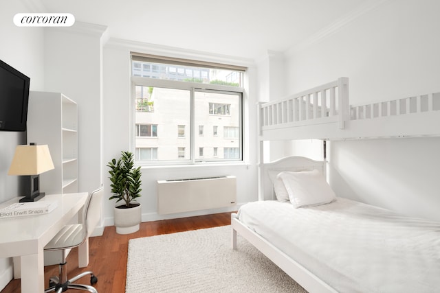 bedroom featuring ornamental molding, visible vents, radiator heating unit, and wood finished floors