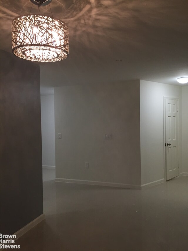 unfurnished room featuring baseboards and concrete flooring