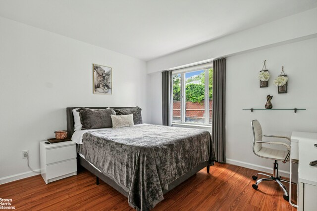 bedroom with baseboards and wood finished floors