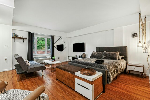 bedroom with baseboards and hardwood / wood-style flooring