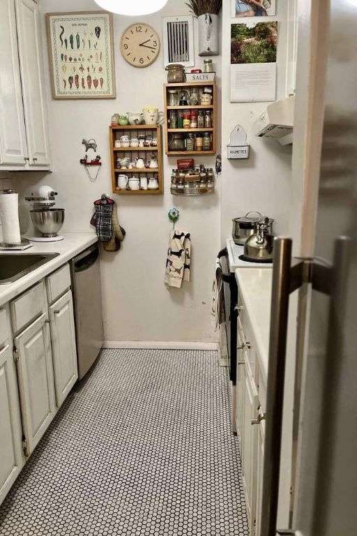 kitchen with white cabinetry, ventilation hood, stainless steel dishwasher, and range