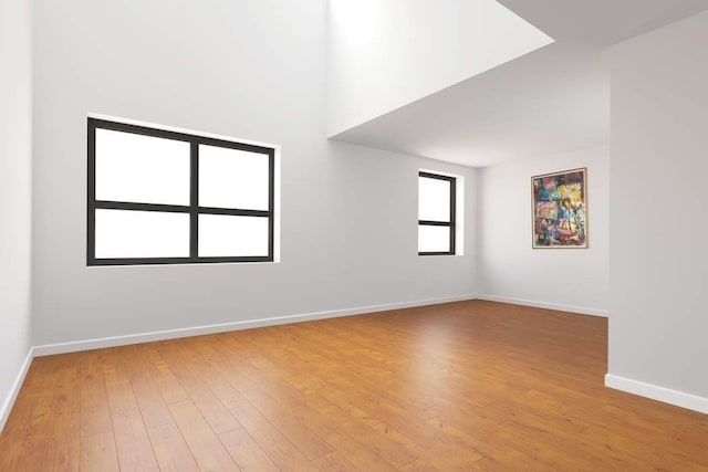 spare room featuring hardwood / wood-style flooring and baseboards