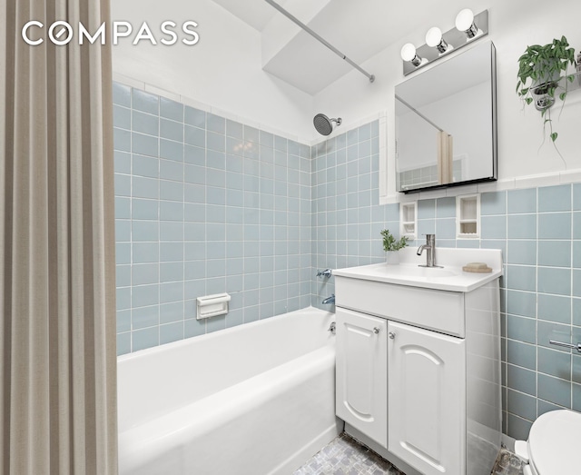full bath featuring vanity, tile walls, shower / bathing tub combination, and toilet