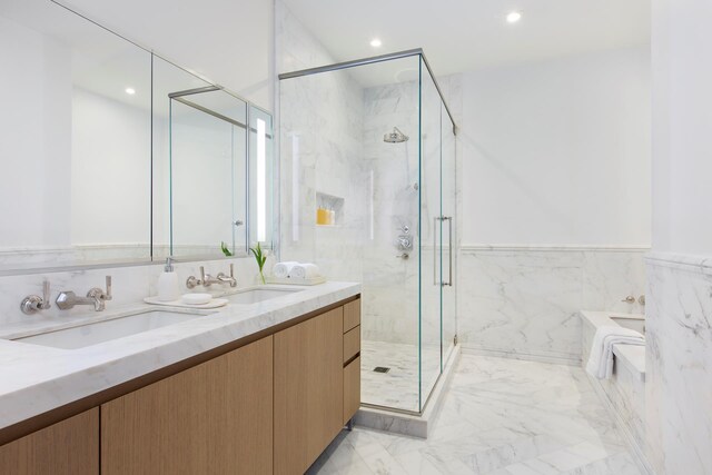 bathroom with marble finish flooring, a marble finish shower, a garden tub, recessed lighting, and double vanity