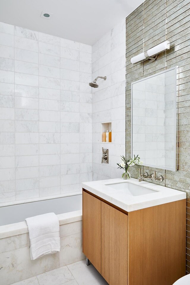 full bathroom with vanity, tiled shower / bath, tile walls, and marble look tile flooring