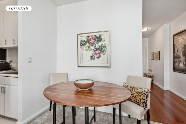 dining area with visible vents, light wood-style floors, and baseboards