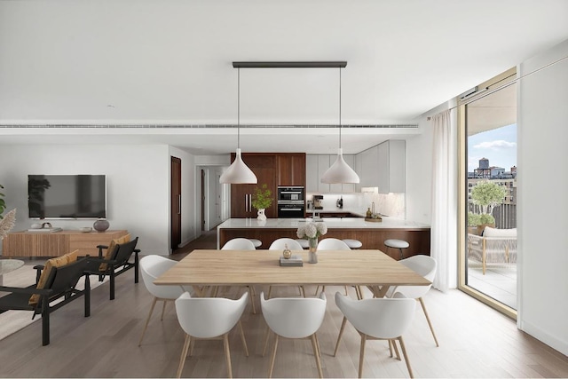 dining room featuring expansive windows and light hardwood / wood-style flooring