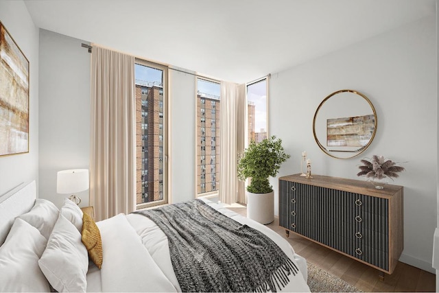 bedroom featuring hardwood / wood-style flooring and a wall of windows