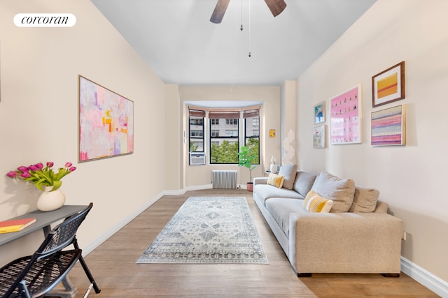 living room featuring ceiling fan, radiator heating unit, and light hardwood / wood-style flooring