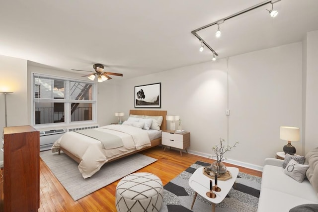 bedroom with ceiling fan, rail lighting, and light wood-type flooring