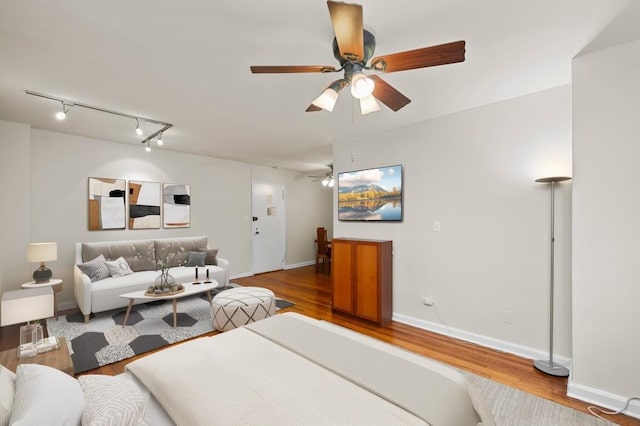 bedroom featuring hardwood / wood-style flooring, track lighting, and ceiling fan