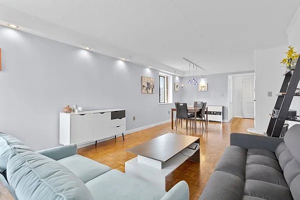 living room featuring heating unit, light parquet floors, and rail lighting