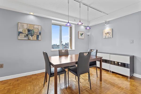 dining space featuring track lighting and light parquet floors