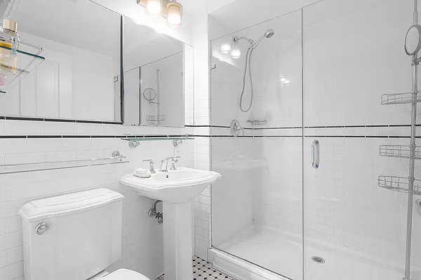 full bathroom with toilet, a shower stall, and a sink